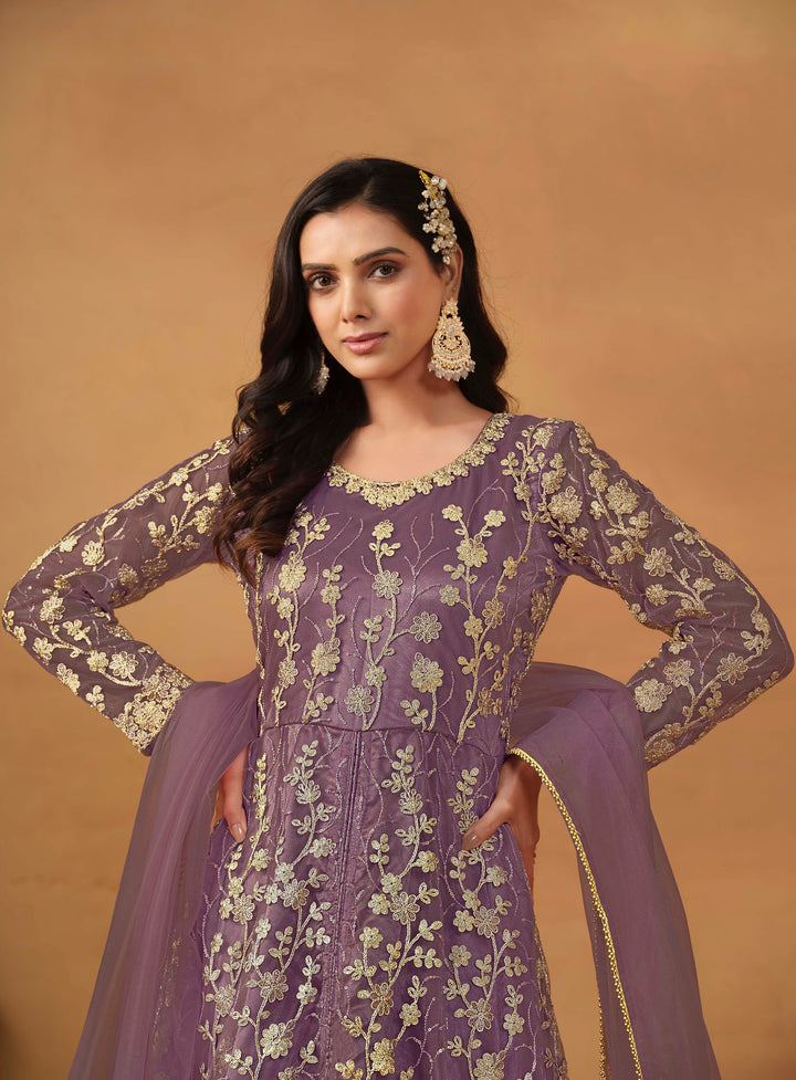 Stunning purple salwar kameez in net with intricate thread embroidery and shimmering sequin work for festive events.