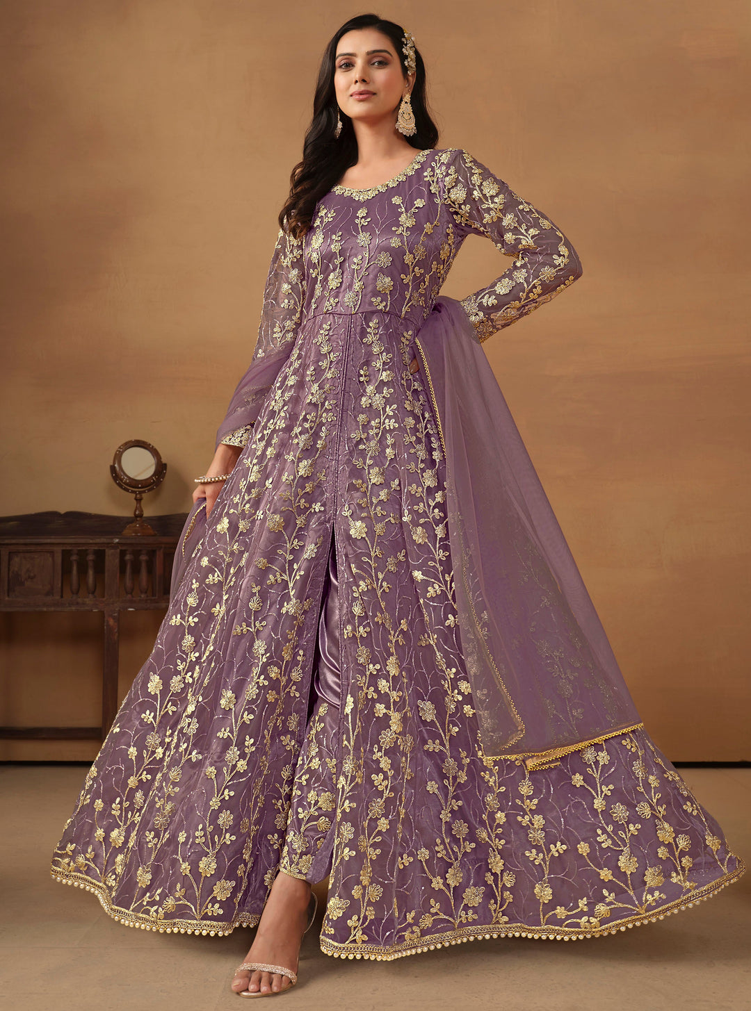 Elegant purple net salwar kameez featuring heavy thread embroidery and sequins, perfect for special occasions.