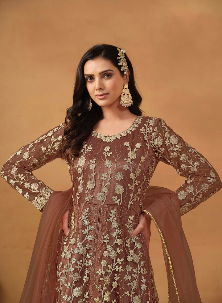 Stunning brown salwar kameez in net with intricate thread embroidery and shimmering sequin work for festive events.