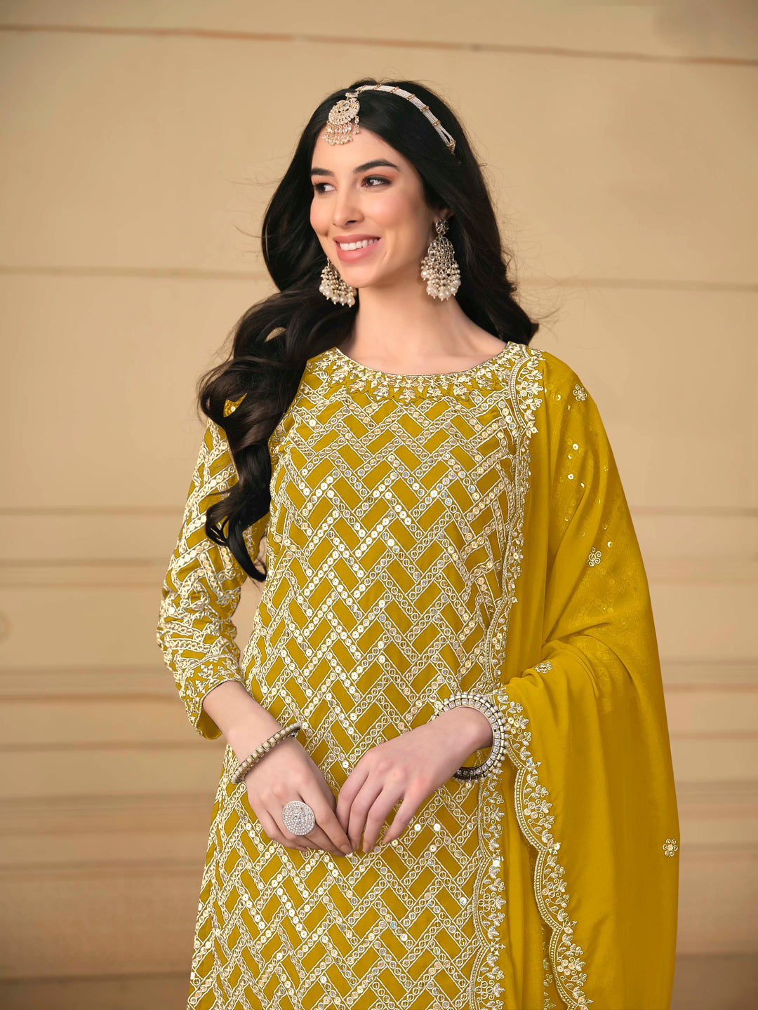 Luxurious mustard faux georgette salwar kameez adorned with exquisite heavy embroidery and sequins, ideal for weddings.