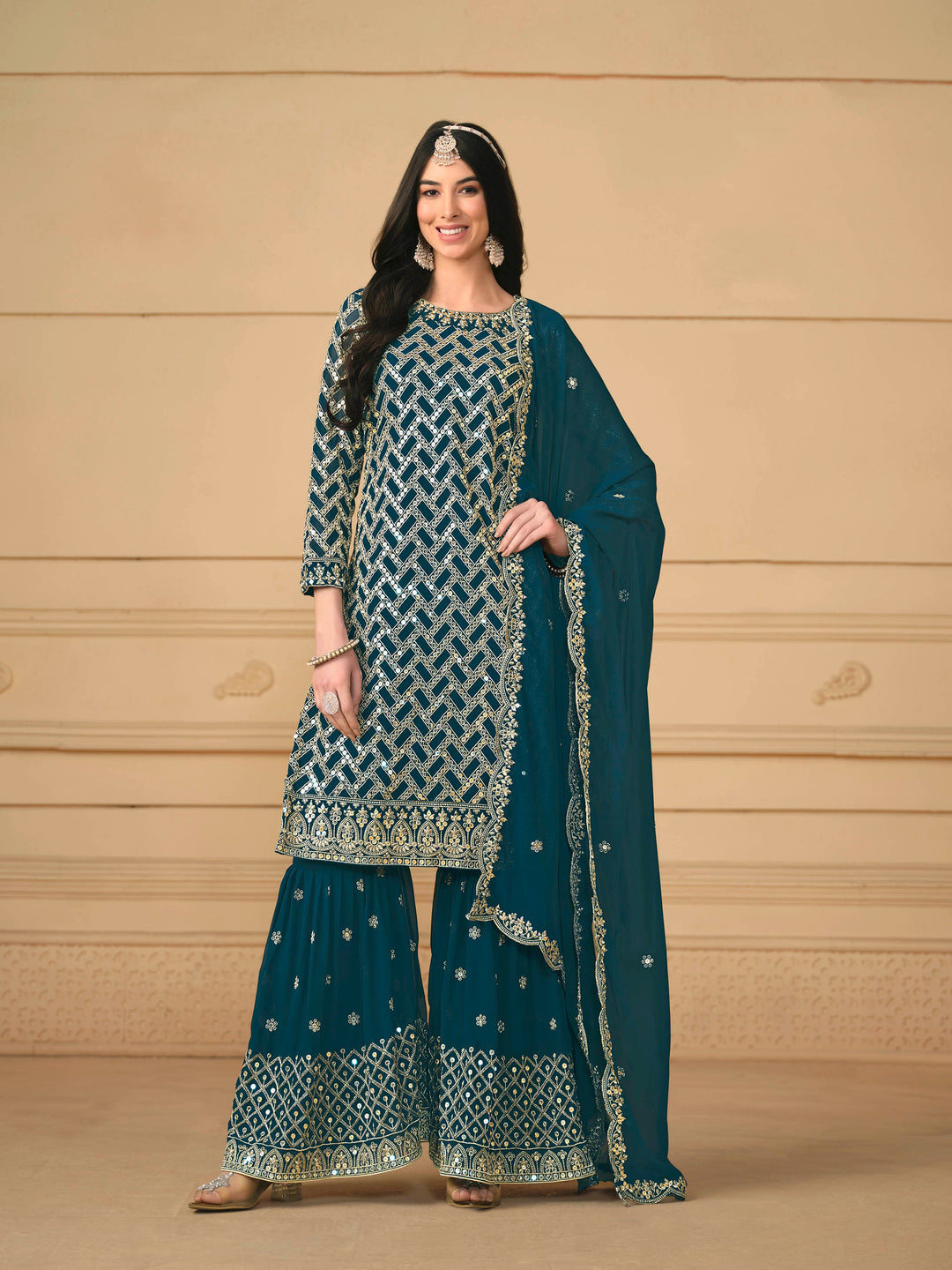 Stunning teal blue salwar kameez in faux georgette with intricate thread embroidery and shimmering sequin work for festive events.