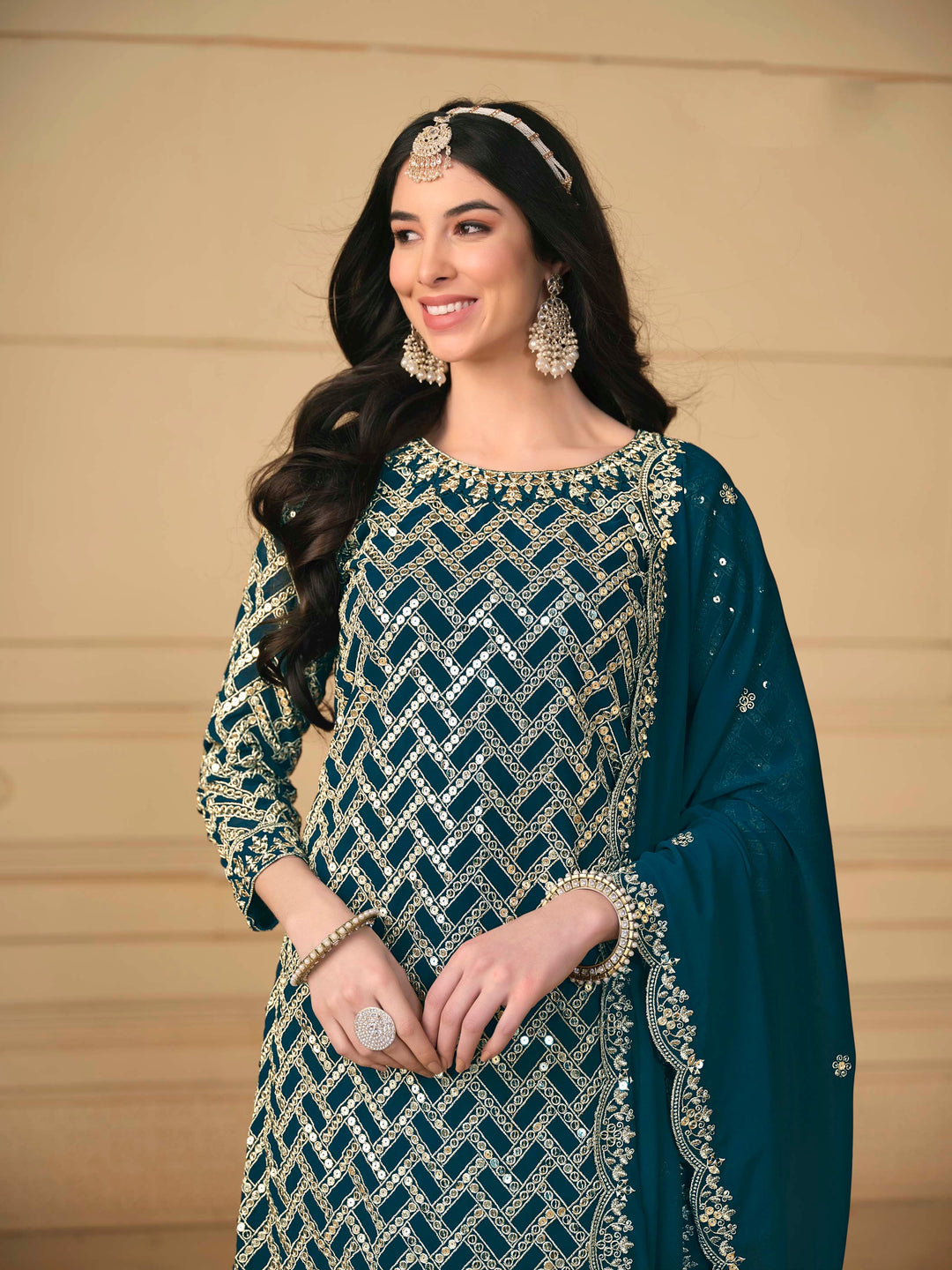 Luxurious teal blue faux georgette salwar kameez adorned with exquisite heavy embroidery and sequins, ideal for weddings.