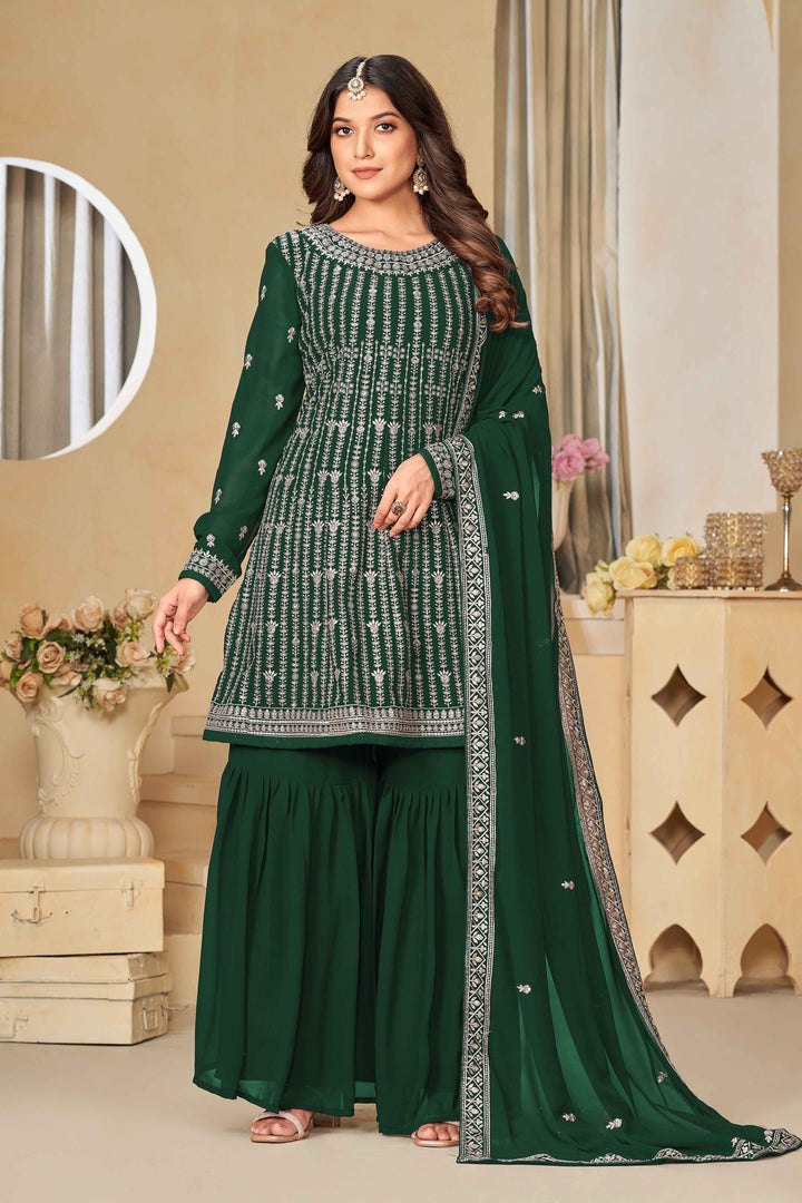 Stunning dark green salwar kameez in faux georgette with intricate thread embroidery and shimmering sequin work for festive events.