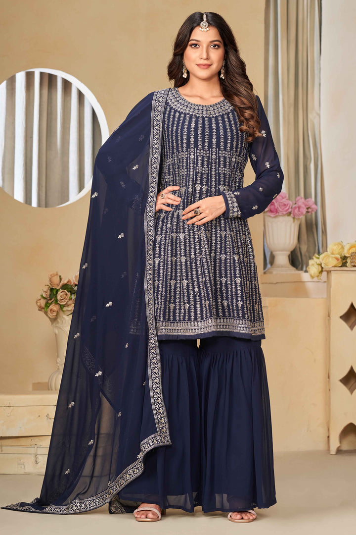 Elegant navy blue faux georgette salwar kameez featuring heavy thread embroidery and sequins, perfect for festive occasions.