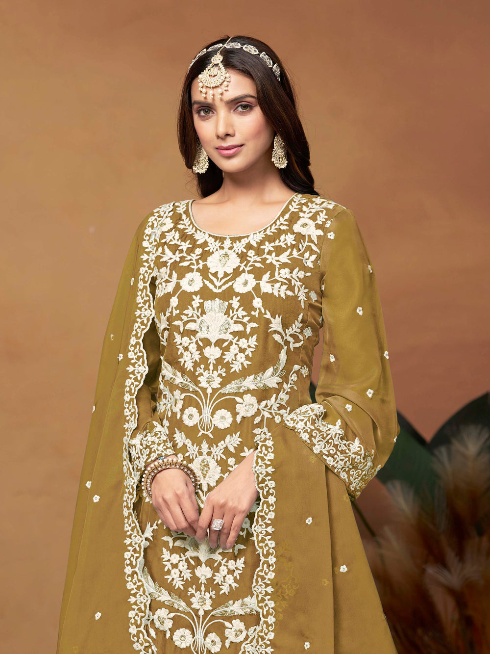 Stunning mustard salwar kameez in soft organza with intricate thread embroidery and shimmering sequin work for festive events.