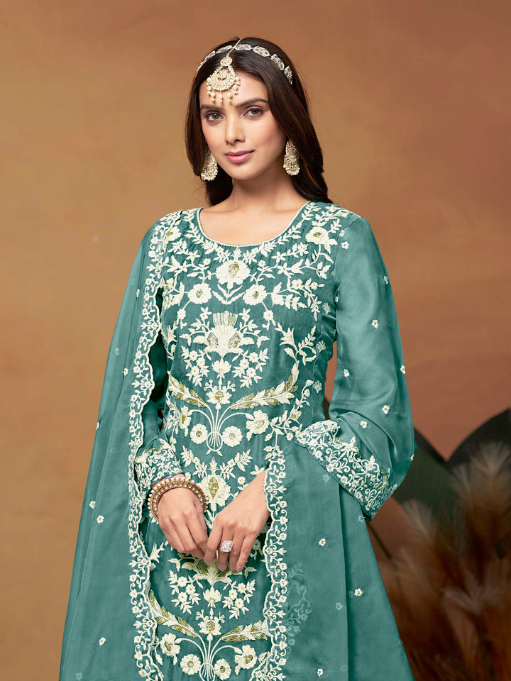 Stunning teal salwar kameez in soft organza with intricate thread embroidery and shimmering sequin work for special events.