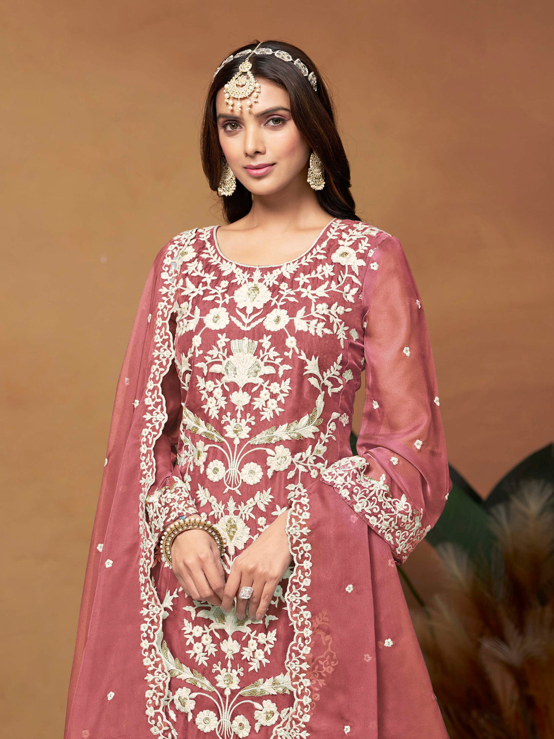 Elegant dusty pink salwar kameez in soft organza with intricate thread embroidery and shimmering sequin work for special events.