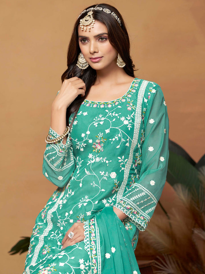 Luxurious turquoise soft organza salwar kameez adorned with exquisite heavy embroidery and sequins, ideal for weddings.