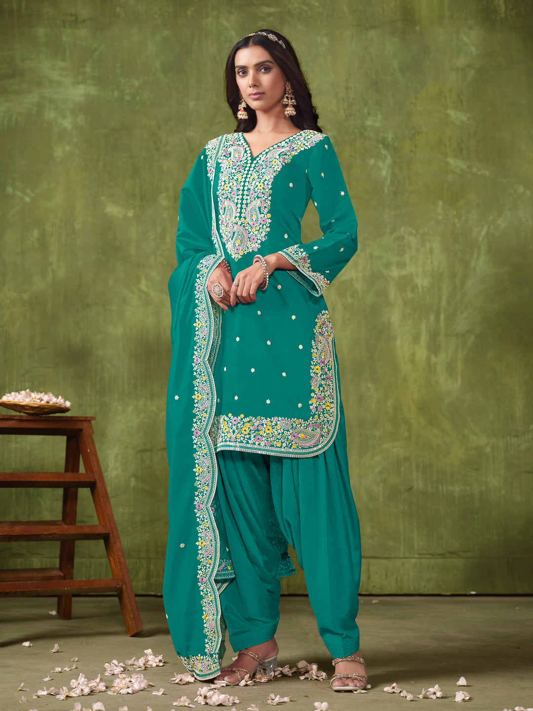 Stunning teal salwar kameez in Roman silk adorned with beautiful heavy thread embroidery and shimmering sequins for celebrations.