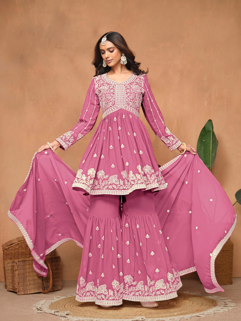 Stylish pink faux georgette salwar kameez featuring exquisite heavy thread embroidery, designed with a free size sharara bottom.