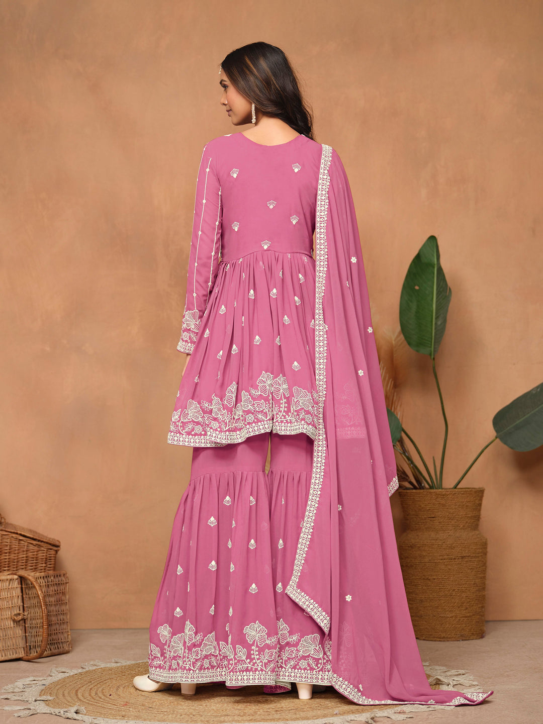 Beautiful pink faux georgette salwar kameez with stunning heavy thread embroidery and a flowing sharara bottom for special occasions.