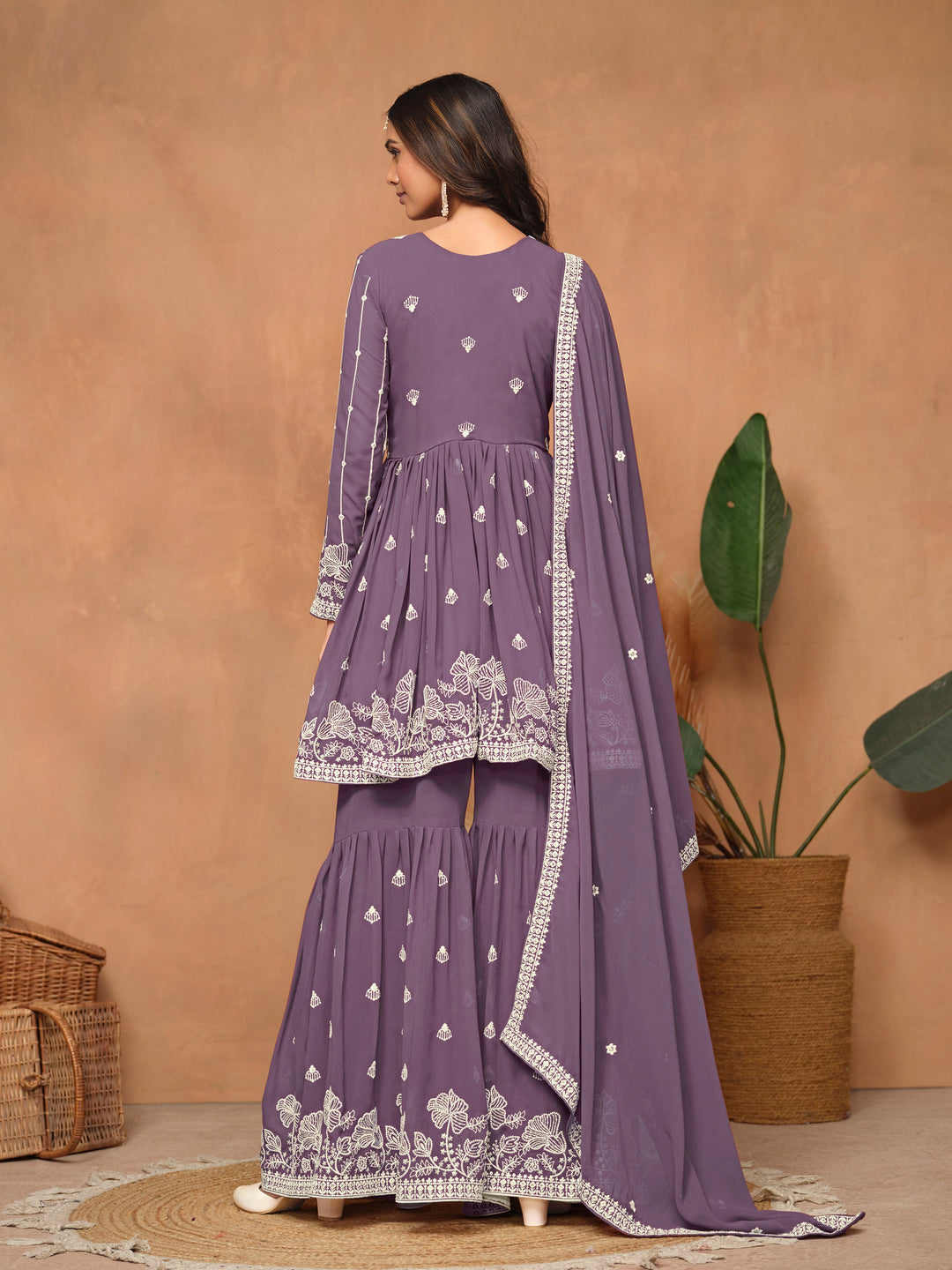 Vibrant purple faux georgette salwar kameez showcasing heavy thread embroidery and a flowing sharara bottom, ideal for weddings.