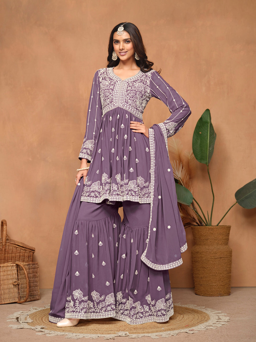 Elegant purple faux georgette salwar kameez featuring intricate heavy thread embroidery and a sharara bottom, perfect for celebrations.