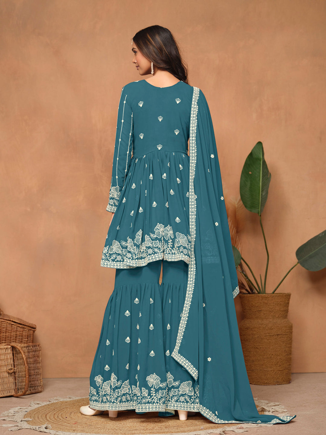 Elegant teal blue faux georgette salwar kameez showcasing heavy thread embroidery and a flowing sharara bottom for special occasions.