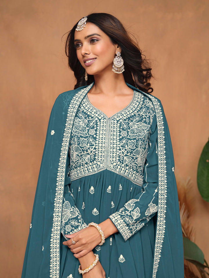 Vibrant teal blue faux georgette salwar kameez adorned with beautiful heavy thread embroidery and sharara bottom, perfect for celebrations.