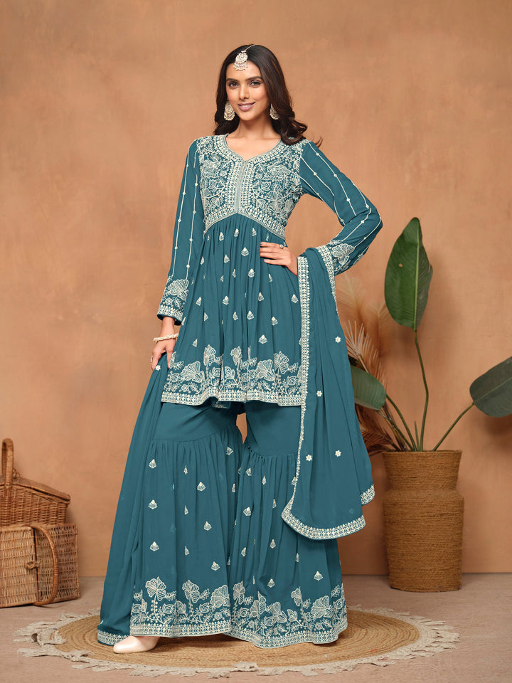 Stunning teal blue faux georgette salwar kameez featuring intricate heavy thread embroidery and a sharara bottom for festive wear.