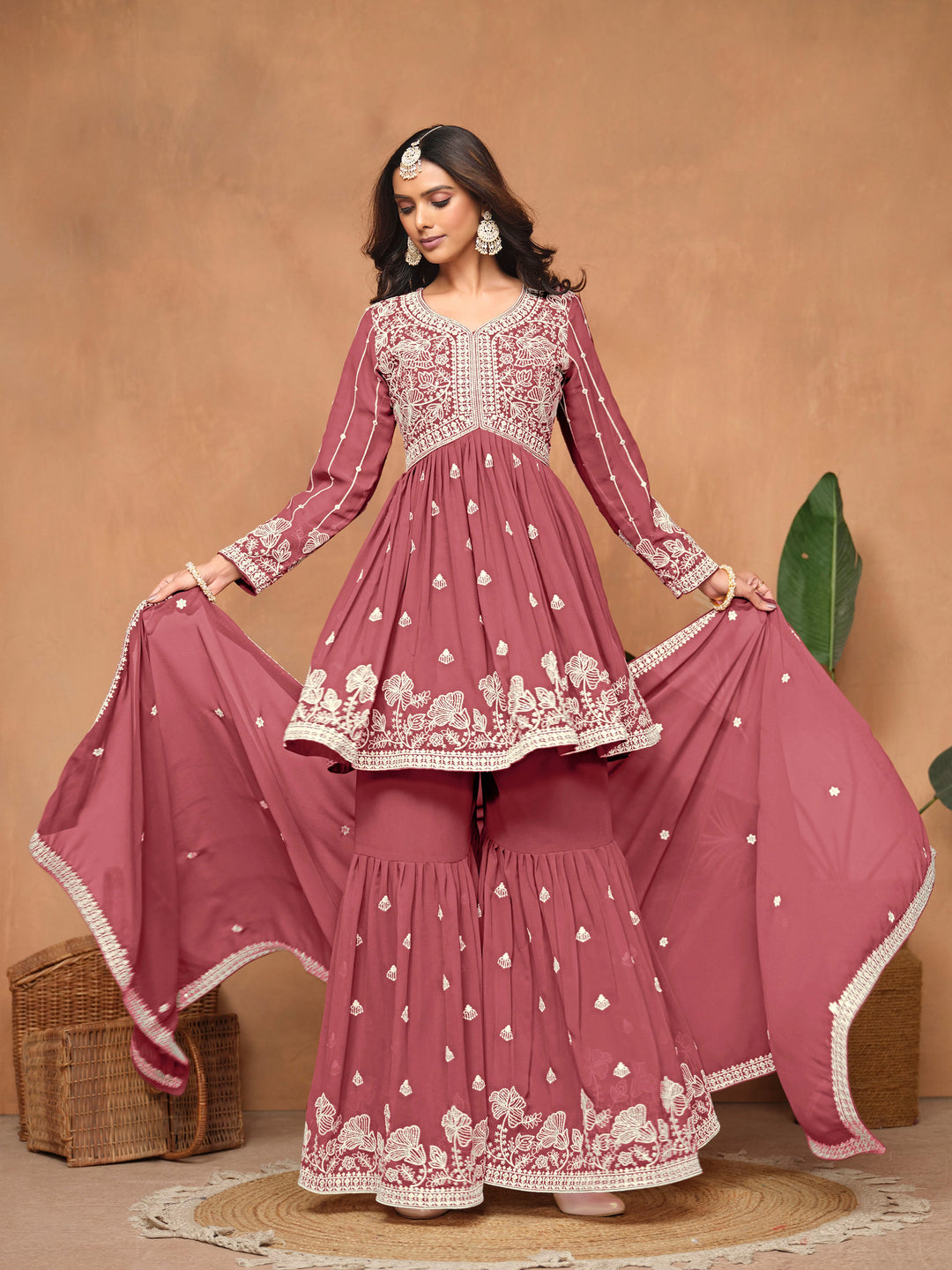 Stunning dark rose faux georgette salwar kameez adorned with exquisite heavy thread embroidery and free size sharara bottom, ideal for weddings.