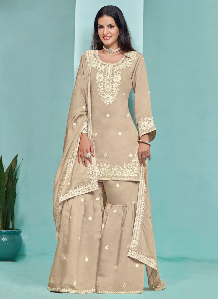 Elegant beige Roman silk salwar kameez featuring intricate heavy thread embroidery and sequins, perfect for formal events.