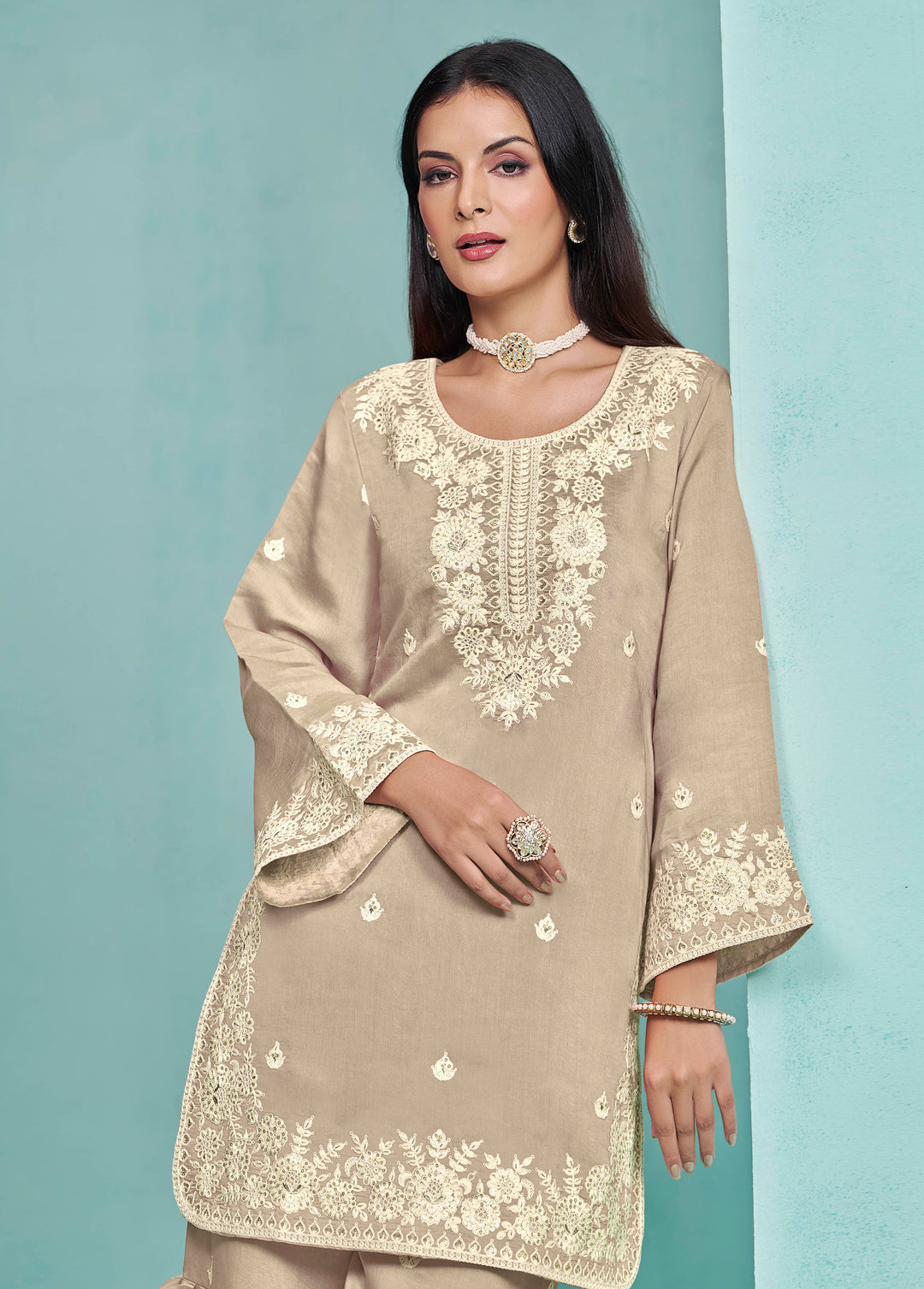 Stunning beige Roman silk salwar kameez adorned with heavy thread embroidery and sequins work, designed with a sharara bottom.