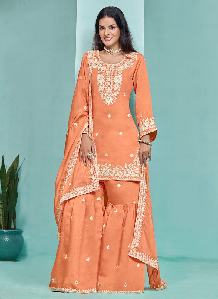 Stunning light orange Roman silk salwar kameez featuring intricate heavy thread embroidery and sequins work, perfect for celebrations.