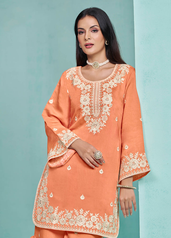 Elegant light orange Roman silk salwar kameez showcasing exquisite heavy thread embroidery and sequins, ideal for weddings.