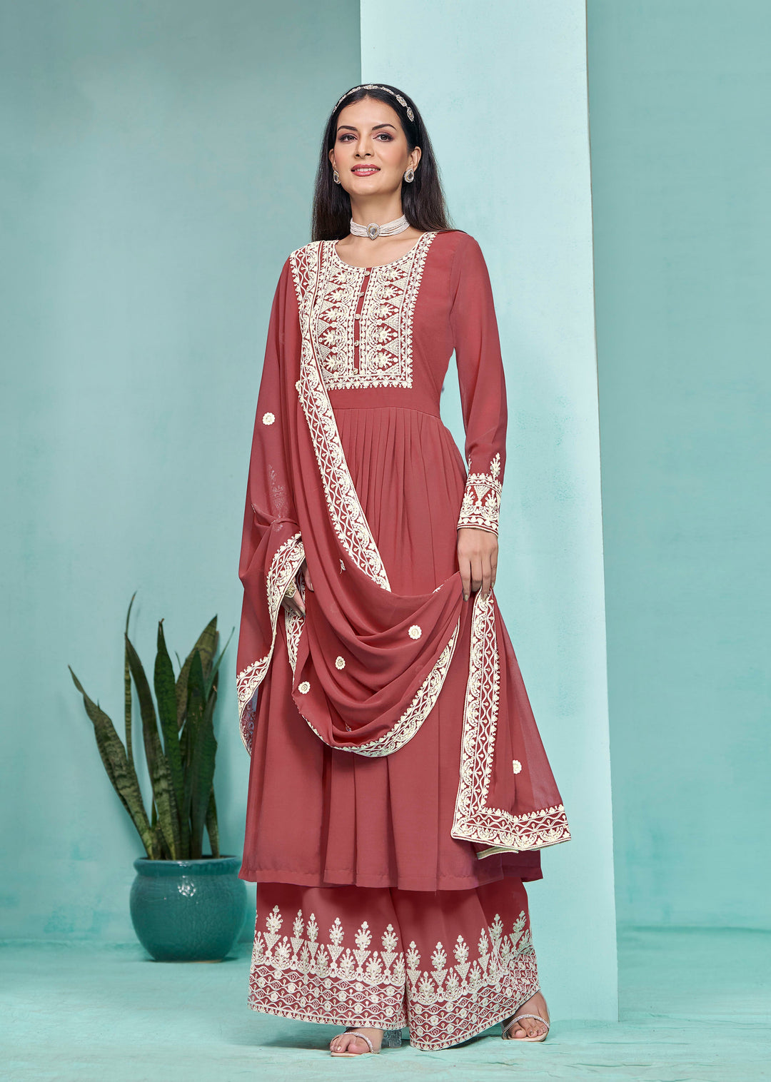 Beautiful brick faux georgette salwar kameez adorned with heavy thread embroidery and sequins, perfect for festive occasions.