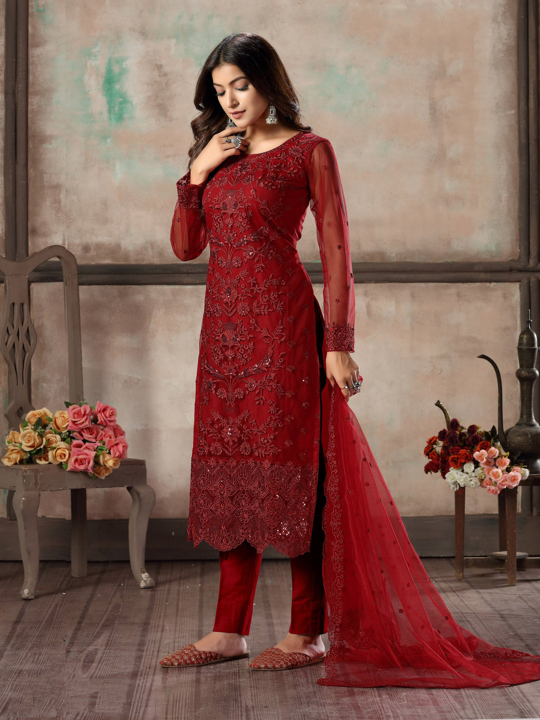 Women's elegant red salwar kameez set with intricate design for traditional occasions.