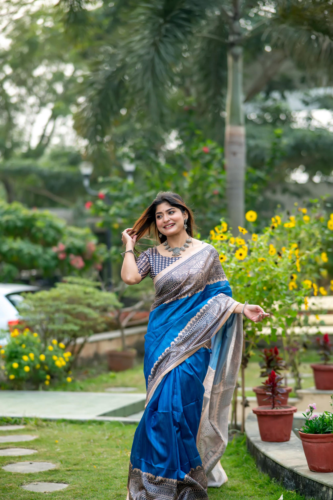 Timeless fiery orange soft tussar silk saree with intricate Madhubani prints and elegant tassels, ideal for traditional wear.