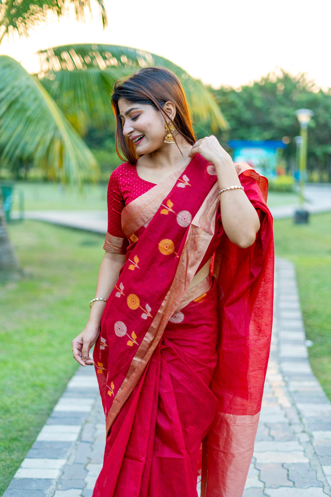 Stunning red pure linen silk saree featuring intricate Jamdani border and brocade blouse design.