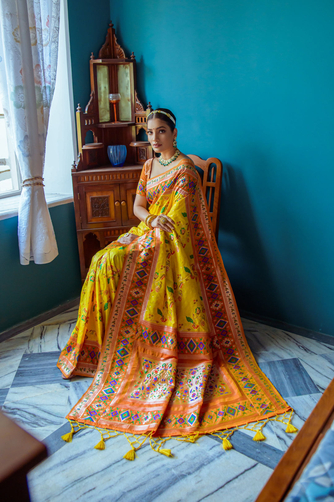 Luxurious Yellow Indian wedding saree with Patola border and meena weaving, ideal for cultural attire.