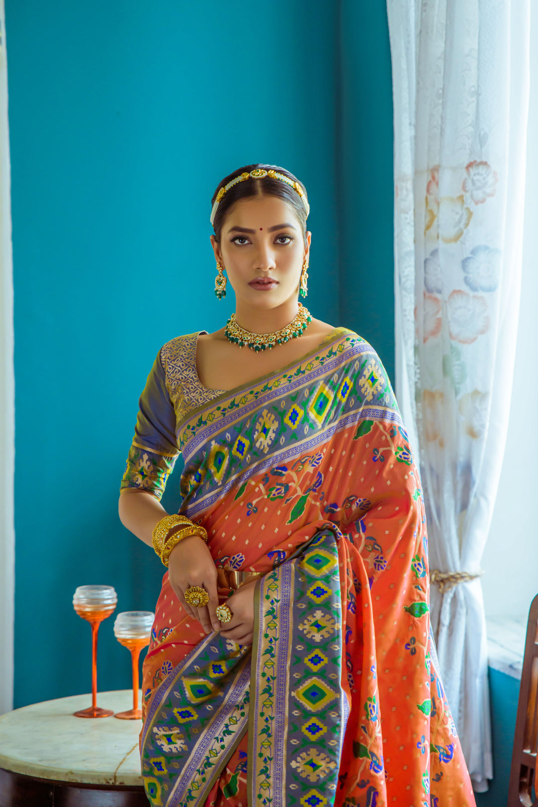 Gorgeous orange Indian saree featuring intricate meena and zari patterns, perfect for cultural occasions.