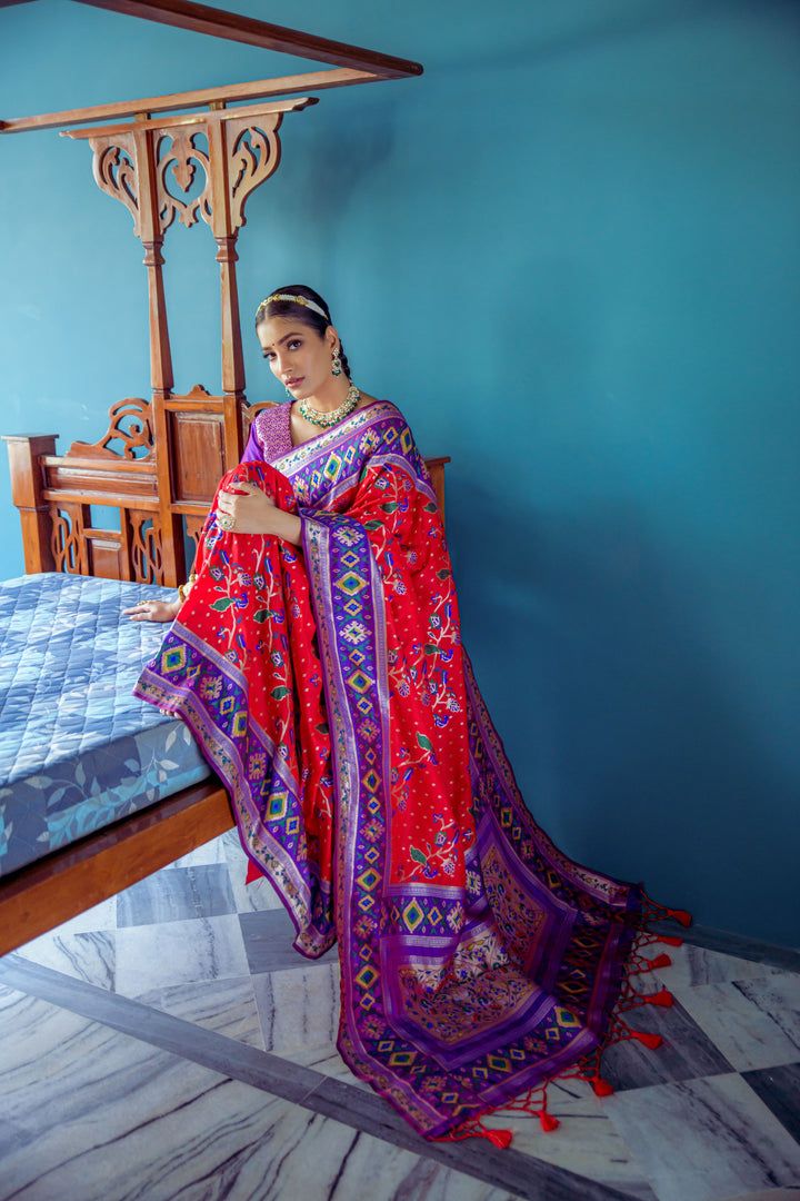 Festive Red Indian saree with rich Patola-style weaving and zari details, ideal for cultural attire.