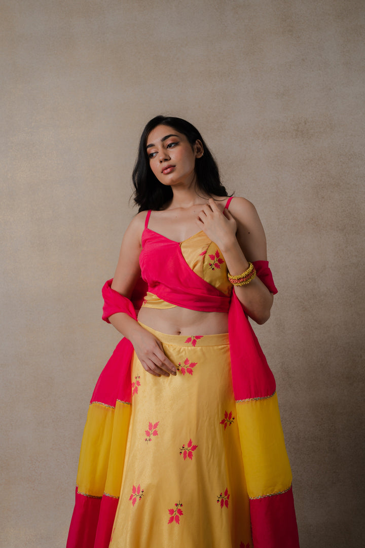 Pink and yellow lehenga set with stunning phulkari embroidery, modern wrap blouse, and lightweight organza dupatta.