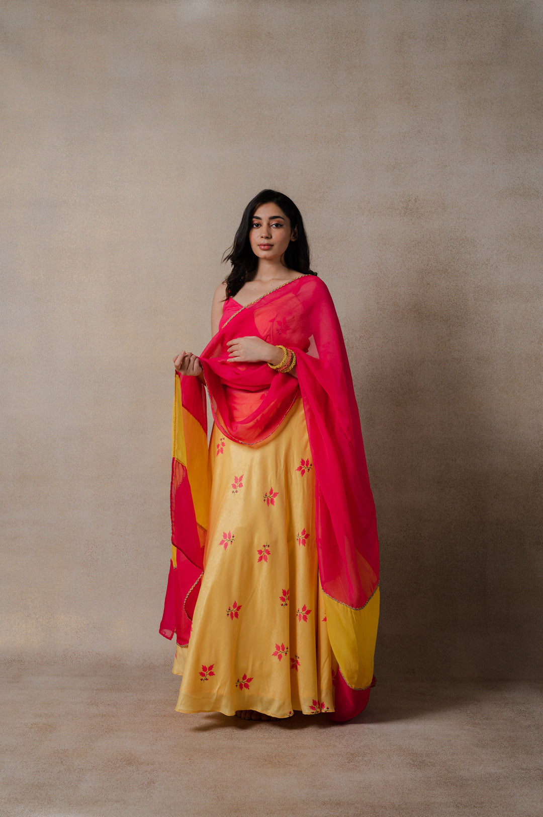 Vibrant pink and yellow phulkari lehenga with a stylish wrap blouse and delicate organza dupatta, designed for festive wear.