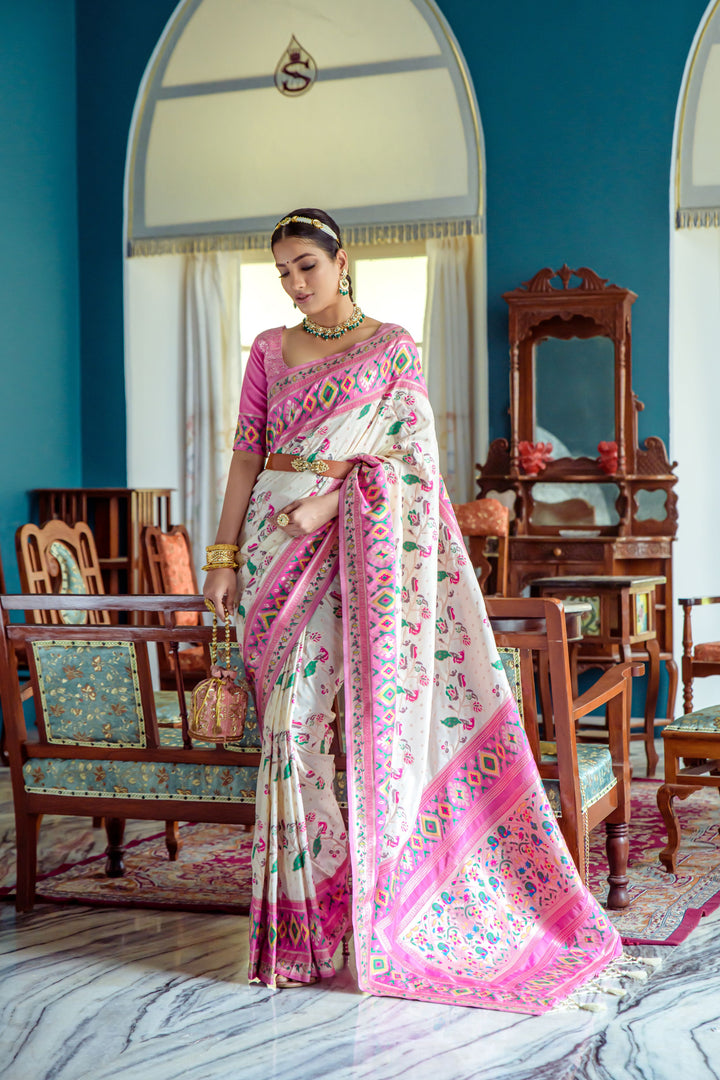 Off-white Indian wedding saree with vibrant Patola weaving and lace border, perfect for bridal wear.