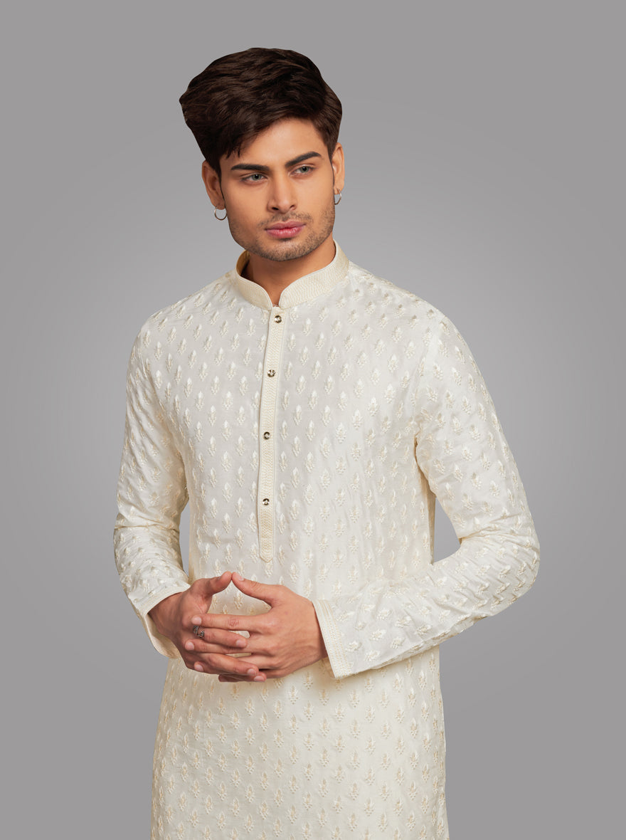 Elegant cream-colored men’s kurta pajama set with embroidered threadwork for special events.