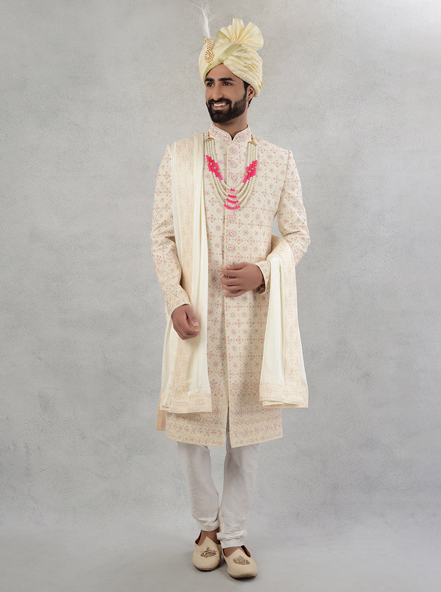 Intricate embroidery on cream and pink sherwani designed for modern grooms in the USA.