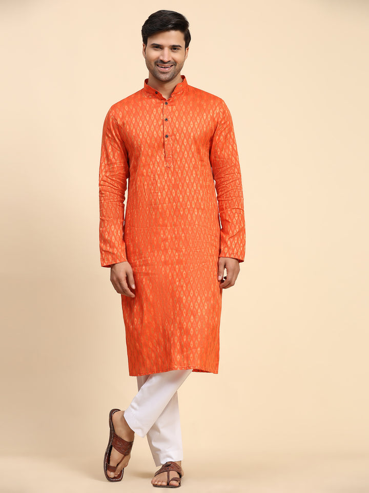 Elegant orange kurta pajama set for men with intricate handwoven motifs, ideal for festive occasions.