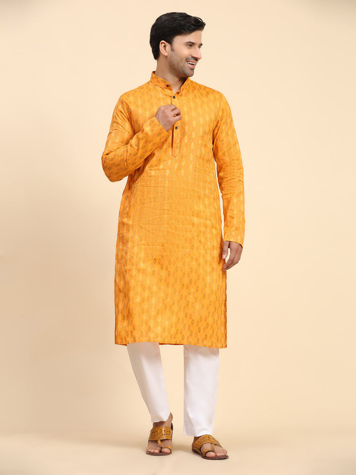 Light orange men’s kurta pajama set with handwoven motifs, perfect for festive occasions.