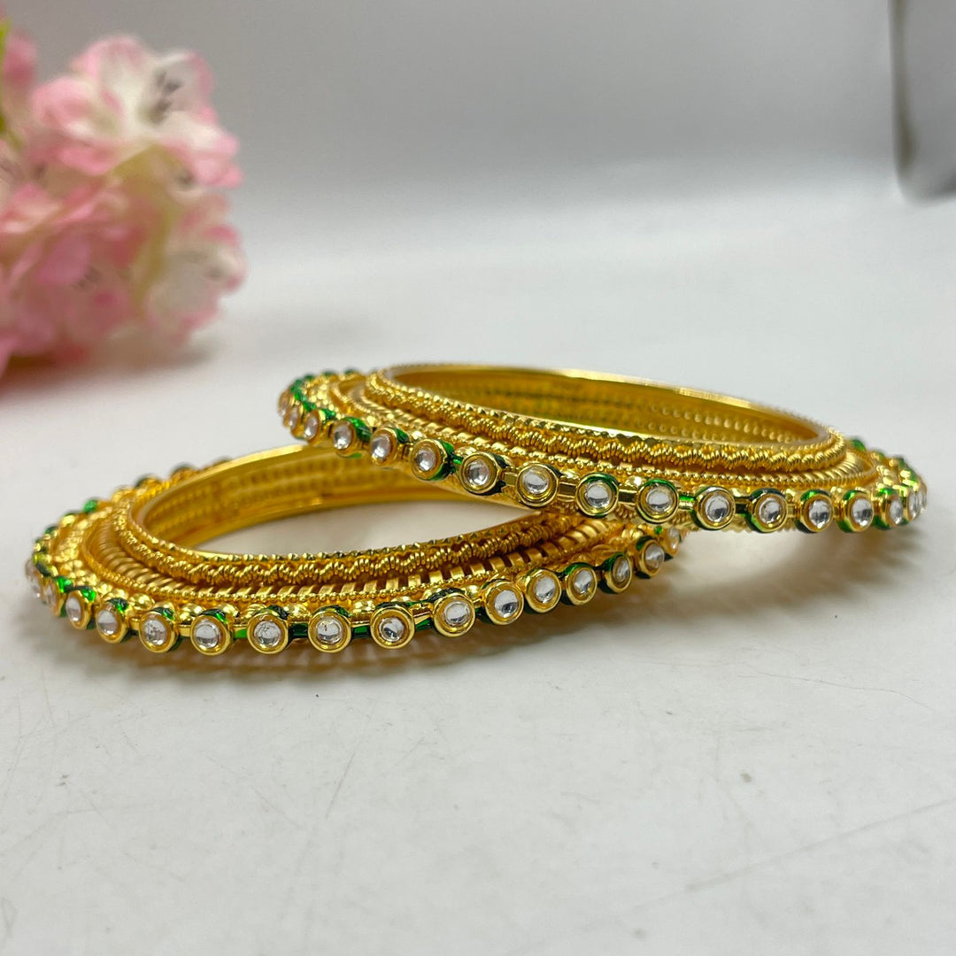 Golden bangles inspired by traditional motifs for cultural celebrations.