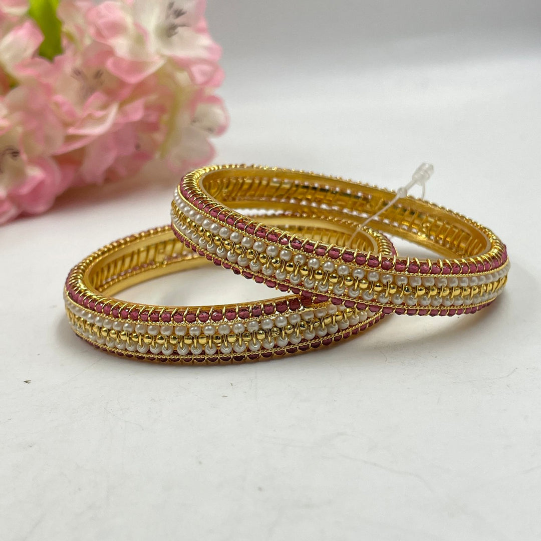 Fashionable golden bangles with playful charms for a youthful vibe.