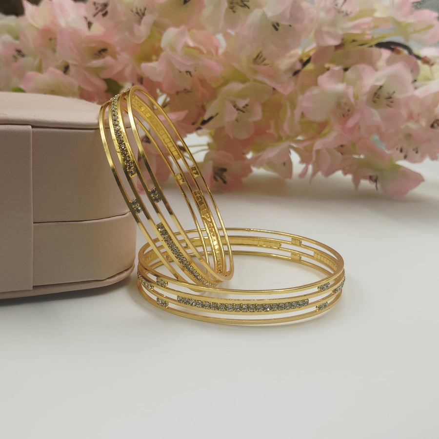 Stylish golden bangles with a twist and turn design.