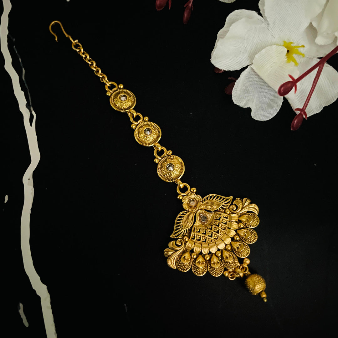 Stylish gold tika designed for brides, adding a radiant touch to their look.