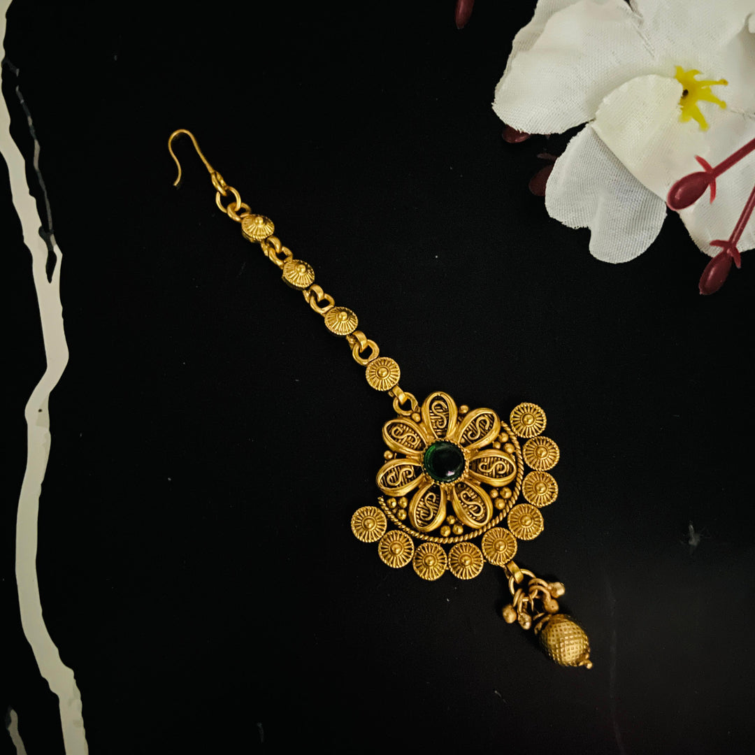 Golden maang tikka with intricate detailing, ideal for special celebrations.