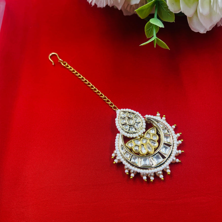 Bridal maang tikka with gold and Kundan elements, a timeless accessory for your wedding day.