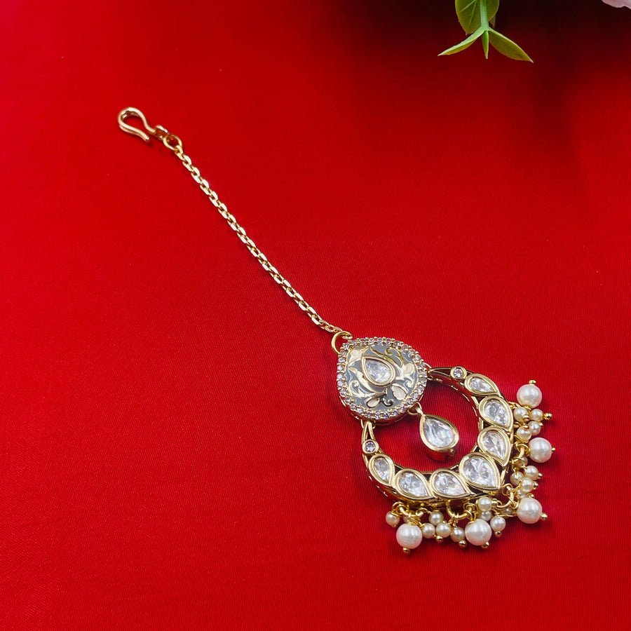 Timeless Kundan maang tikka with gold elements, a classic bridal accessory for wedding celebrations.