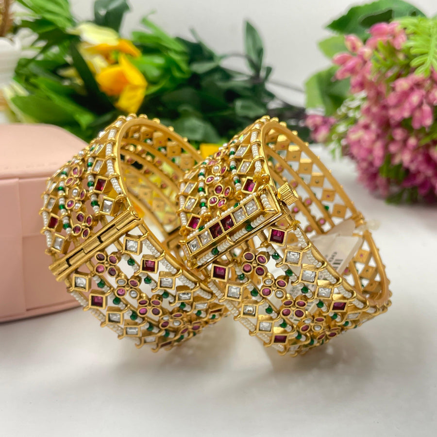 Golden bangles adorned with colored enamel for a vibrant touch.