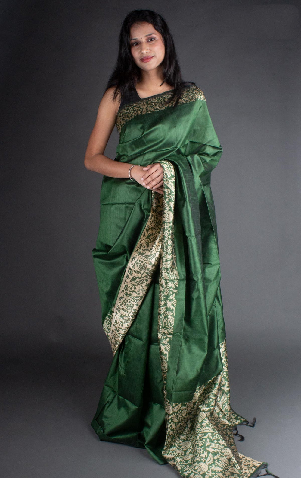 Elegant dark green raw silk saree with a rich pallu, perfect for traditional Indian weddings and ceremonies.