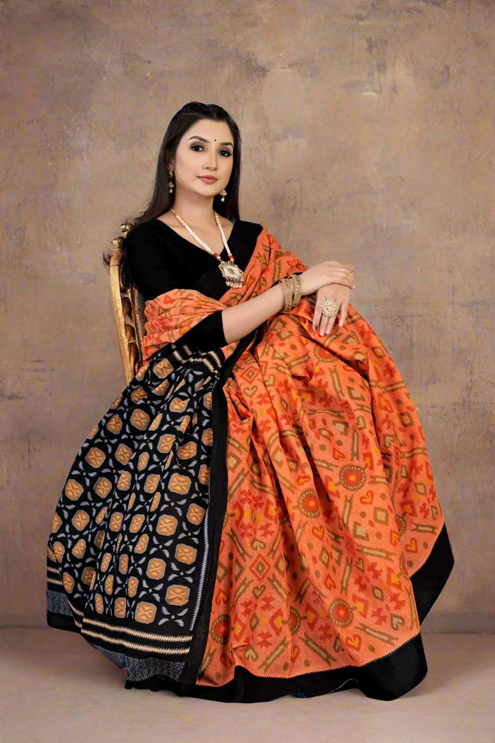 Elegant orange and black batik saree, perfect for cultural gatherings and weddings.