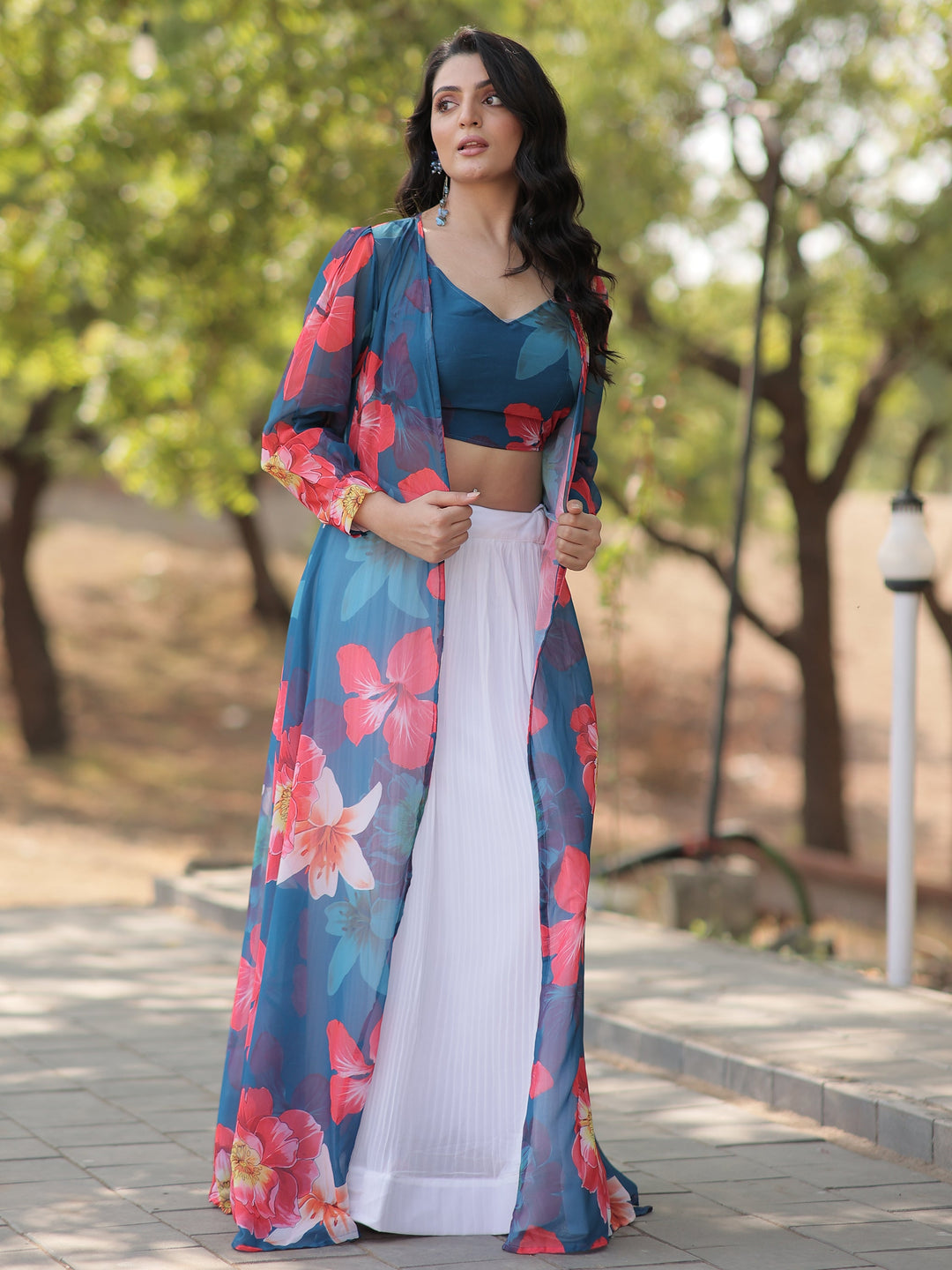 Make a graceful statement with this beautiful white georgette crush lehenga. Fully stitched and available in size L, the lehenga features a classic white fabric with a sophisticated textured finish.  The look is elevated by a sky-blue georgette crop top adorned with vibrant floral prints, adding a fresh and contemporary touch. Completing the ensemble is a sky-blue georgette jacket, also detailed with floral prints, which adds an extra layer of elegance.  Perfect for festivals, parties, or casual gatherings,